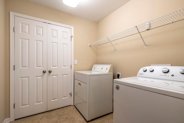 washroom featuring washing machine and clothes dryer and a textured ceiling