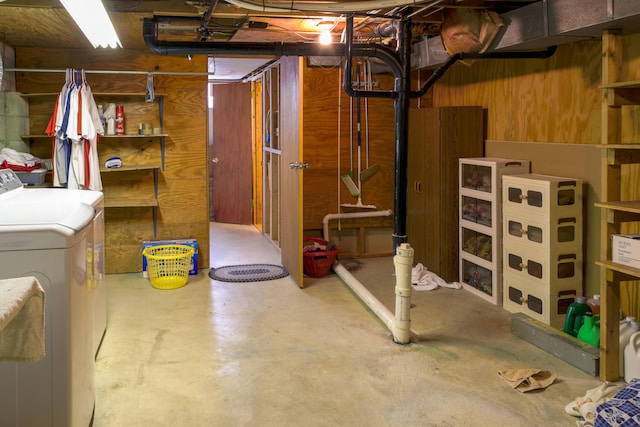 basement featuring washer and clothes dryer and wooden walls