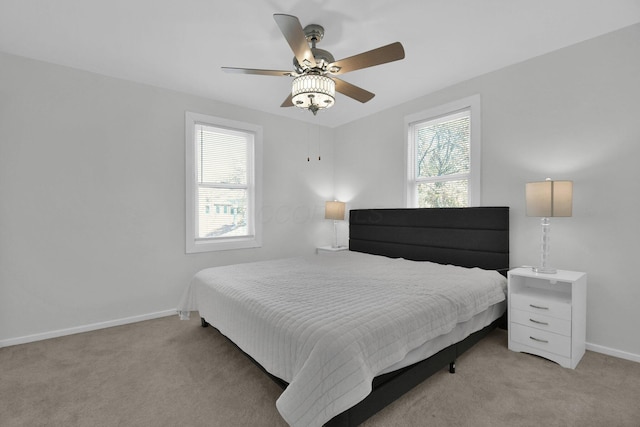 bedroom with light carpet, multiple windows, and ceiling fan