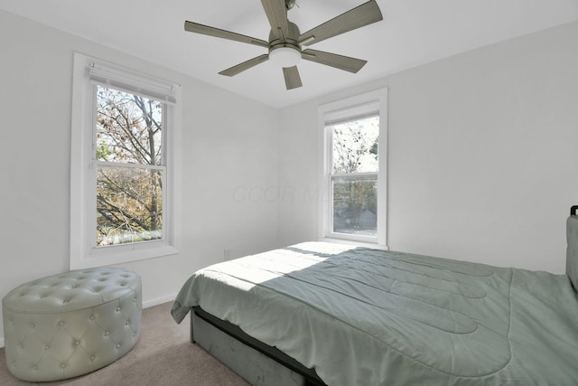 carpeted bedroom featuring ceiling fan and multiple windows