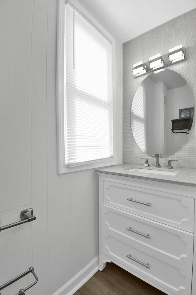 bathroom featuring decorative backsplash, a healthy amount of sunlight, vanity, and wood-type flooring