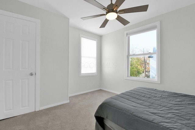 carpeted bedroom with multiple windows and ceiling fan