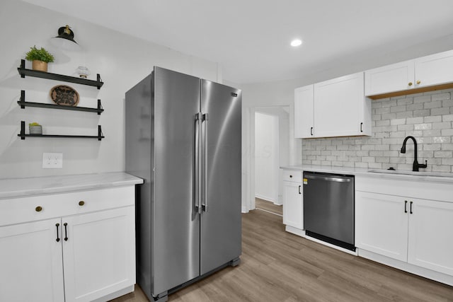 kitchen with white cabinets, stainless steel appliances, and light wood-type flooring