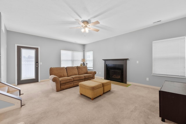 carpeted living room featuring ceiling fan and a tile fireplace