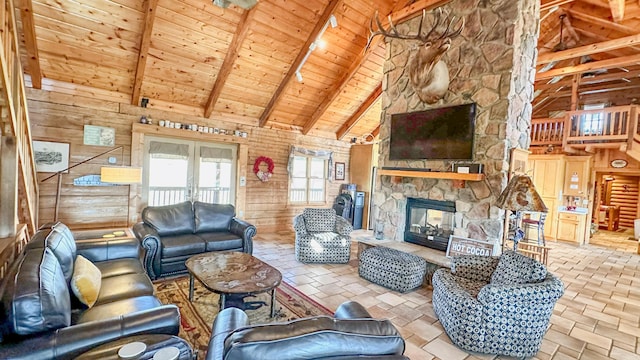 living room with beamed ceiling, wood ceiling, a fireplace, and wood walls