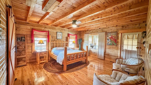 bedroom with multiple windows and wooden walls