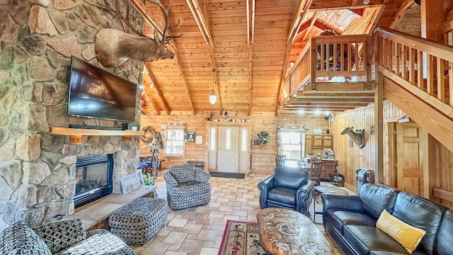 living room featuring vaulted ceiling with beams, wood walls, a fireplace, and wood ceiling