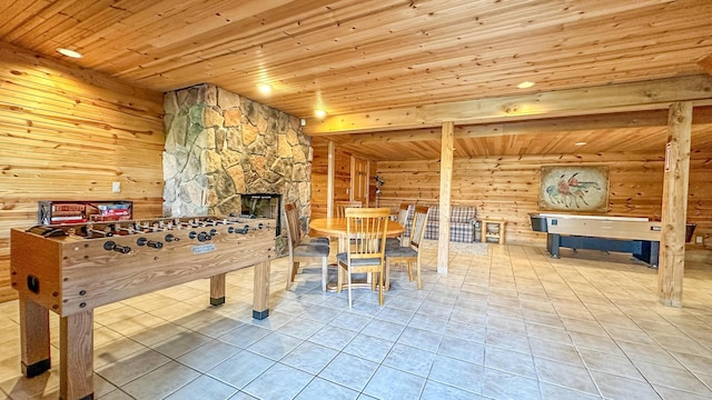 game room with tile patterned flooring, a stone fireplace, and wooden ceiling