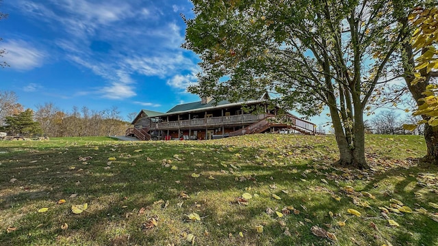 back of property featuring a lawn and a deck