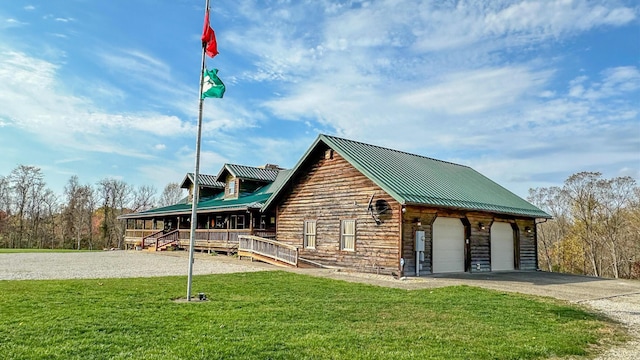 view of front of property featuring covered porch, a front yard, and a garage