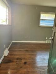 unfurnished room with dark wood-type flooring and a healthy amount of sunlight