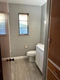 bathroom with hardwood / wood-style floors, vanity, and toilet