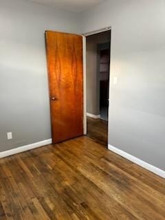 unfurnished bedroom featuring a closet and dark wood-type flooring