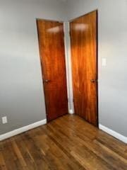 unfurnished bedroom with a closet and dark wood-type flooring