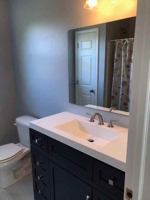 bathroom featuring a shower with curtain, vanity, and toilet