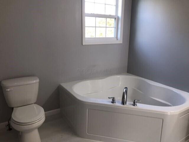 bathroom with a tub and toilet