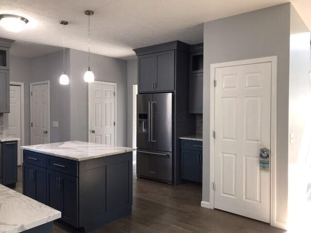 kitchen featuring a center island, high end fridge, dark hardwood / wood-style flooring, and pendant lighting