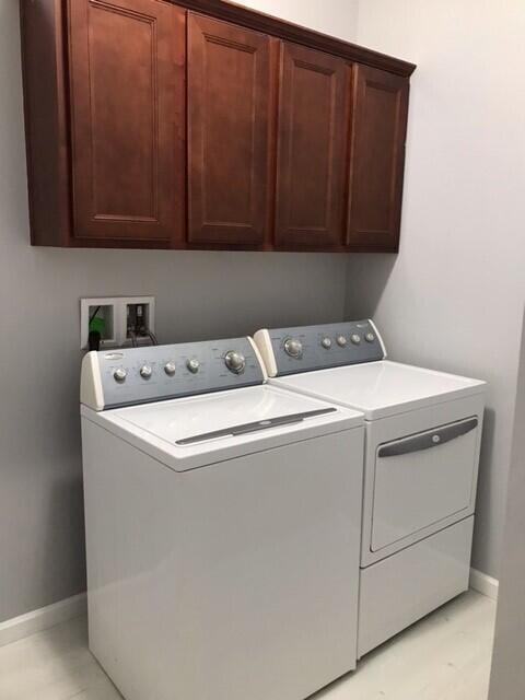 washroom featuring cabinets and washing machine and dryer