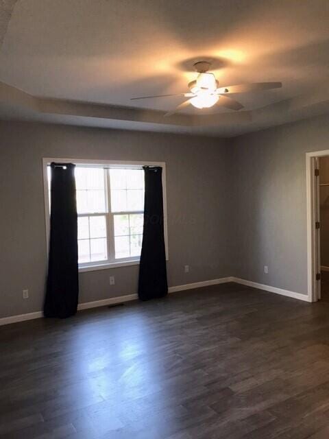 spare room with ceiling fan and dark wood-type flooring