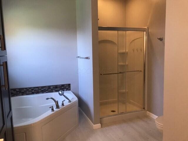 bathroom featuring hardwood / wood-style flooring, toilet, and independent shower and bath