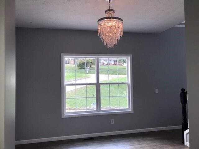 interior space featuring hardwood / wood-style floors and an inviting chandelier