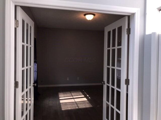 unfurnished room with french doors and dark hardwood / wood-style floors