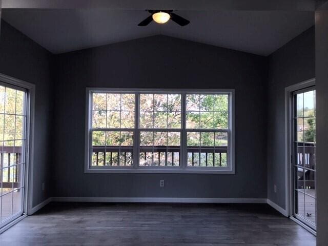 empty room with dark hardwood / wood-style floors, ceiling fan, and lofted ceiling