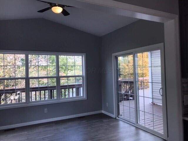 empty room with dark hardwood / wood-style floors, ceiling fan, and lofted ceiling