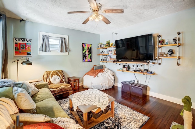 living room featuring ceiling fan, dark hardwood / wood-style flooring, and a textured ceiling