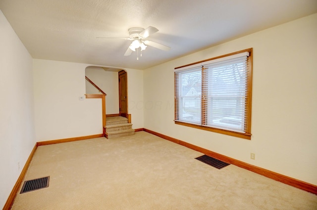 carpeted spare room with ceiling fan