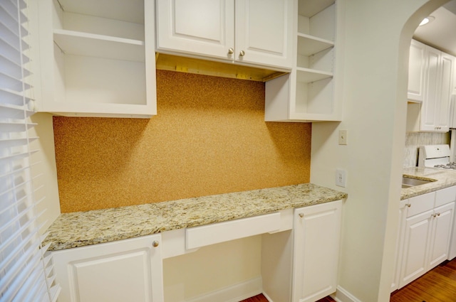 kitchen with white cabinetry, light stone countertops, and dark wood-type flooring