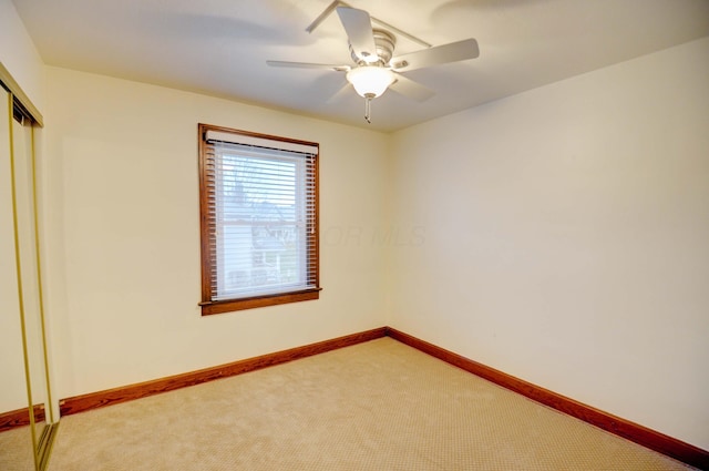 unfurnished bedroom featuring ceiling fan, a closet, and carpet floors