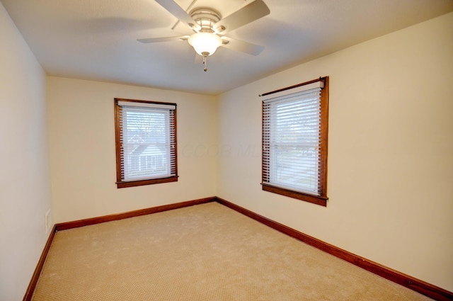 empty room with ceiling fan and light colored carpet