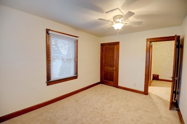 unfurnished bedroom featuring light carpet and ceiling fan