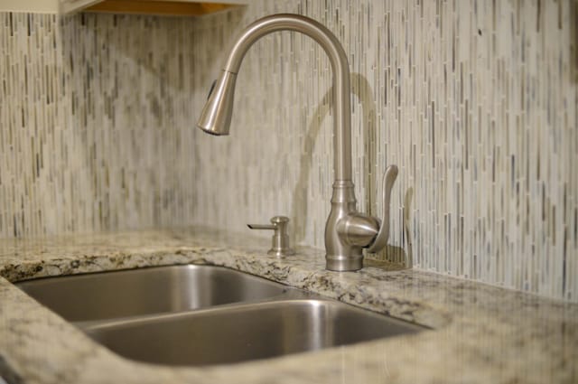 room details featuring light stone countertops and sink