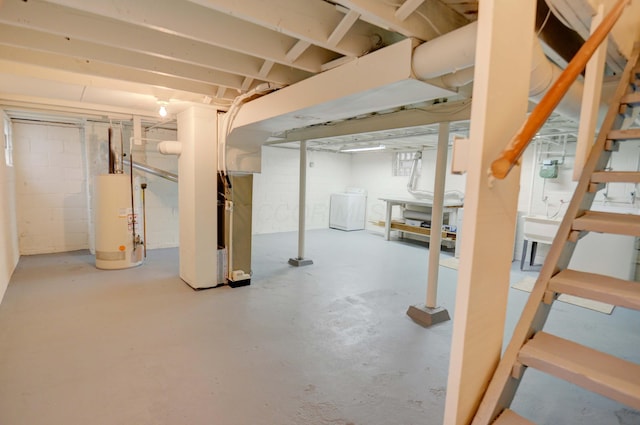 basement with heating unit, gas water heater, and washer / clothes dryer