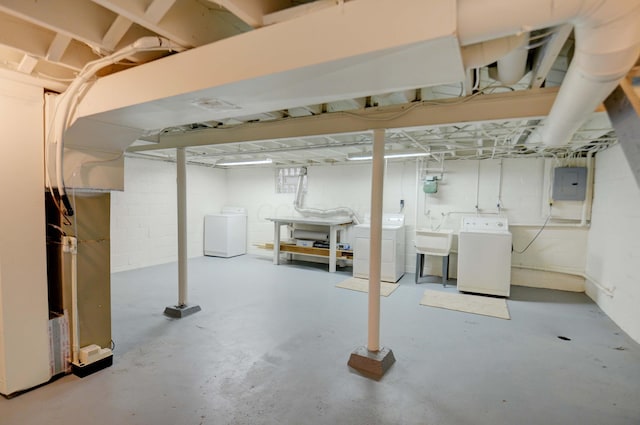 basement with washing machine and dryer, sink, and electric panel