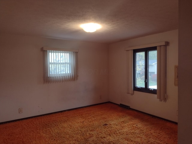 carpeted spare room with a textured ceiling