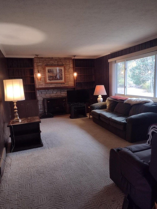 living room with carpet flooring, a stone fireplace, and wooden walls