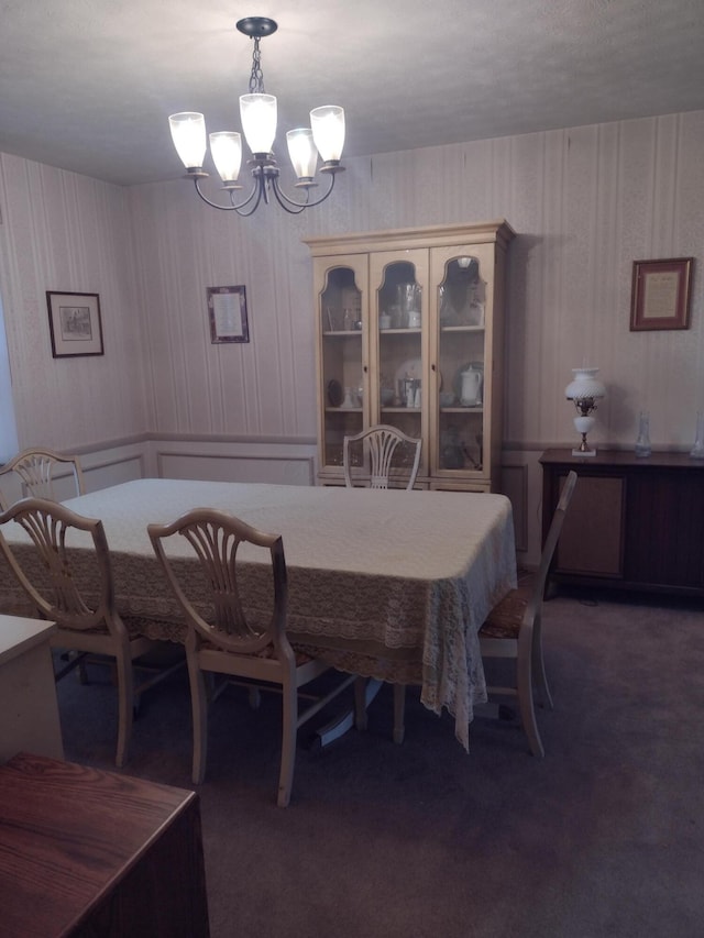 carpeted dining space with an inviting chandelier