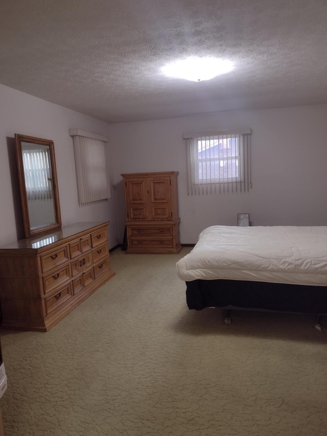 unfurnished bedroom featuring a textured ceiling and light carpet