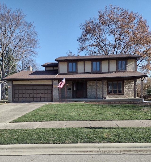 view of front of home with covered porch, a garage, and a front lawn