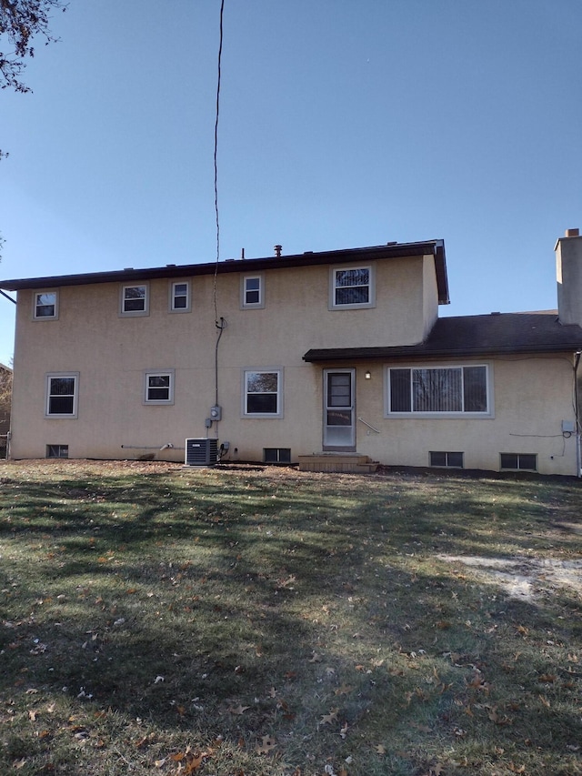 back of house with a lawn and central AC