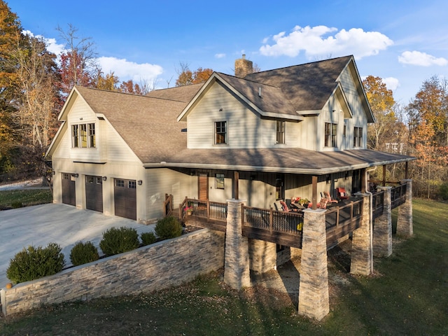 view of front of house featuring a front lawn, covered porch, and a garage