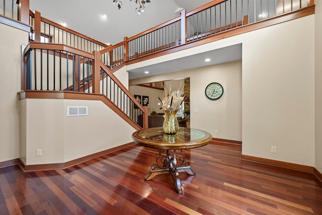 stairs featuring wood-type flooring and a high ceiling