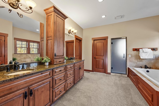 bathroom featuring vanity, an inviting chandelier, and separate shower and tub