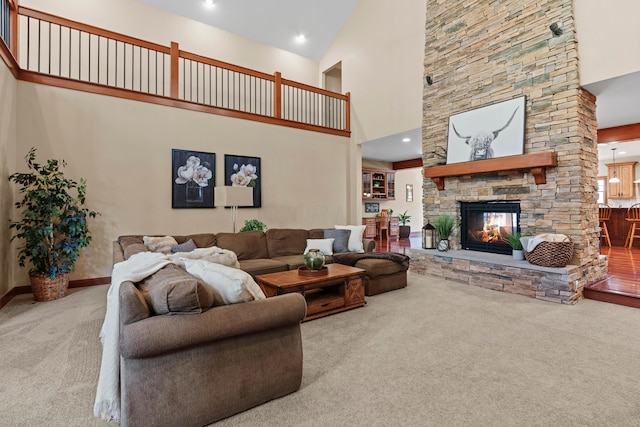 living room featuring carpet floors, a stone fireplace, and high vaulted ceiling