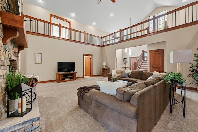 living room featuring ceiling fan, light colored carpet, a fireplace, and high vaulted ceiling