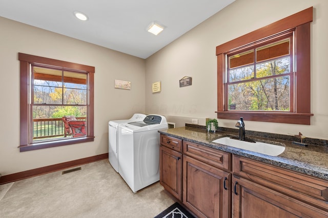 laundry area featuring light carpet, separate washer and dryer, a wealth of natural light, and sink