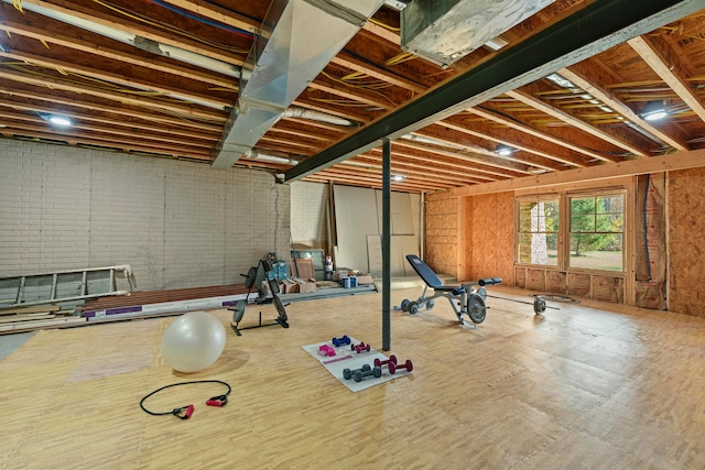 workout room featuring brick wall